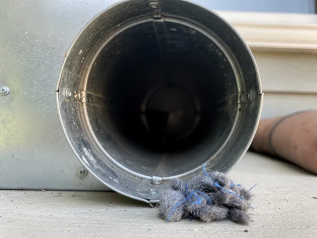 Wrentham Dryer Vent Cleaning technician using specialized equipment to clear severe dryer vent blockage in Wrentham